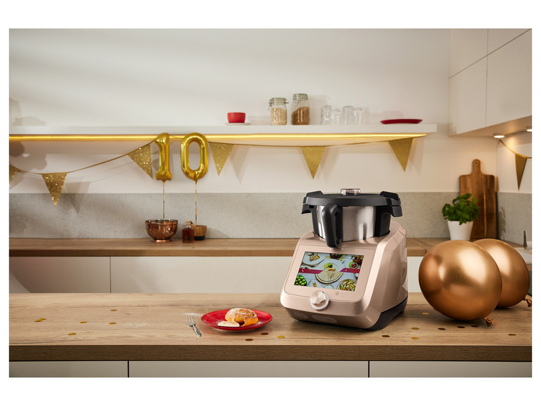 Een gouden multicooker in een keuken met gouden ballonnen.