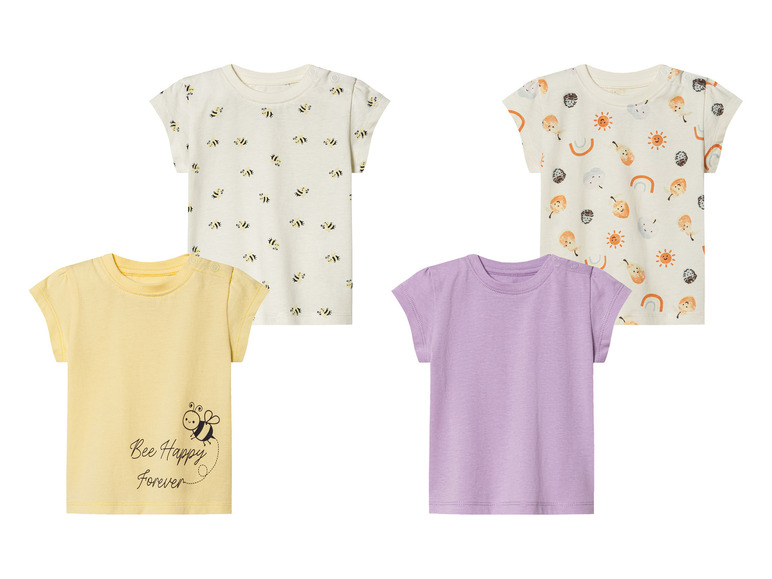 Vier baby t-shirts met verschillende prints: bijen, fruit, zon en regenboog.
