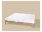 Houten bed met wit matras op beige achtergrond.