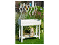 Witte houten plantenbak met planten en een trellis