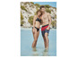 Een stel in zwemkleding staat in het water op het strand.