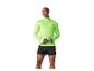 Homme en haut de course vert lime à manches longues et short noir, tenant une bouteille d'eau.