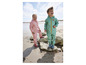 Deux enfants portent des vêtements de pluie sur la plage.