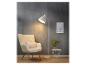 Un lampadaire blanc avec un fauteuil, une plante et une table d'appoint.
