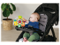 Baby in Graco kinderwagen met speeltje.