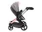 Een roze en grijze kinderwagen met grote wielen.