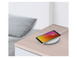 Een tablet op een draadloze oplader op een nachtkastje.