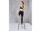 Vrouw in sportkleding springt over een trainingshurdleset.