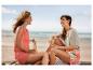 Deux femmes boivent des boissons sur la plage.