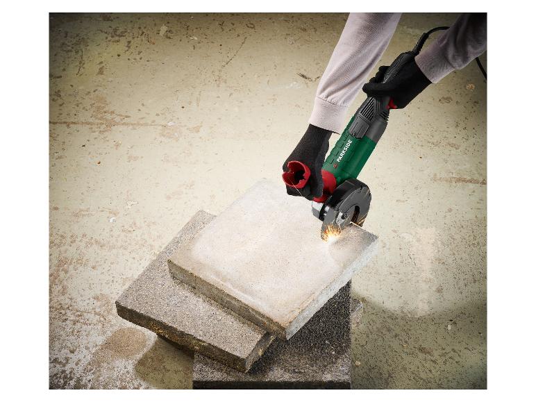 Personne coupant des dalles de béton avec une meuleuse d'angle, créant des étincelles.