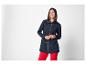 Lachende vrouw in marineblauwe parka en rode broek