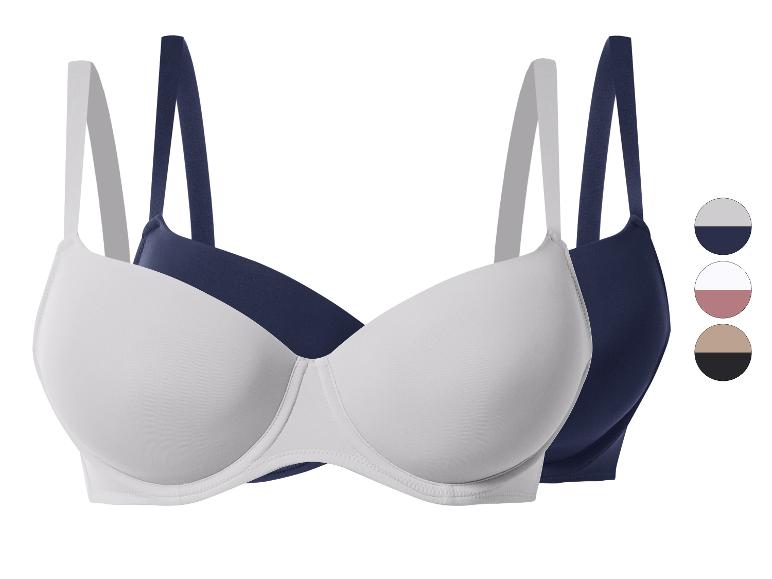 Set van twee beha's, één witte en één marineblauwe, met gladde cups en verstelbare bandjes.
