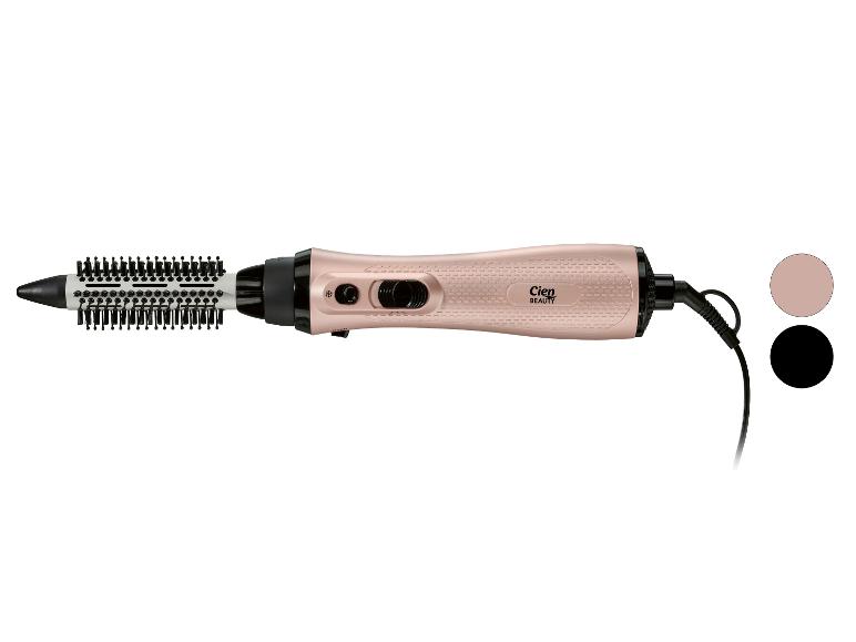 Brosse soufflante or rose avec une tête de brosse ronde et un cordon noir.