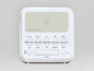 Une radio Silvercrest blanche avec un chargeur sans fil Qi, un bouton snooze et des commandes.