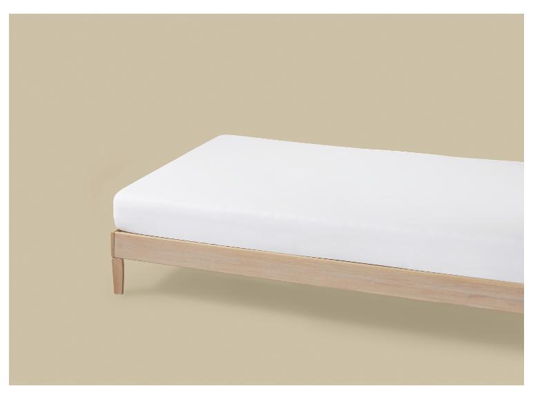 Bed met een licht houten frame en een eenvoudig wit matras.