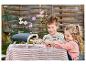 Deux enfants jouent avec un four à pizza jouet et une pizza dans le jardin.