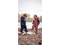 Deux enfants en combi-pantalon de pluie et bottes en caoutchouc jouant dans une flaques.