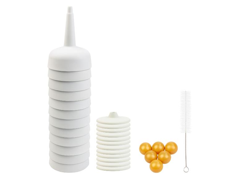 Un entonnoir empilable, une brosse de nettoyage et des perles de verre rondes.