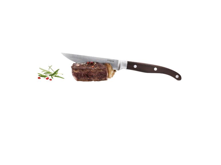 Steak avec couteau, romarin et poivre sur fond blanc.