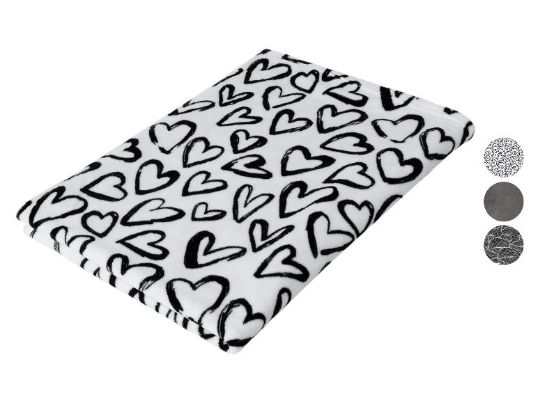 Couverture blanche à cœurs noirs avec trois échantillons de motifs ronds.