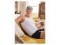 Man ontspannen in een wit tanktop en zwarte boxershorts.