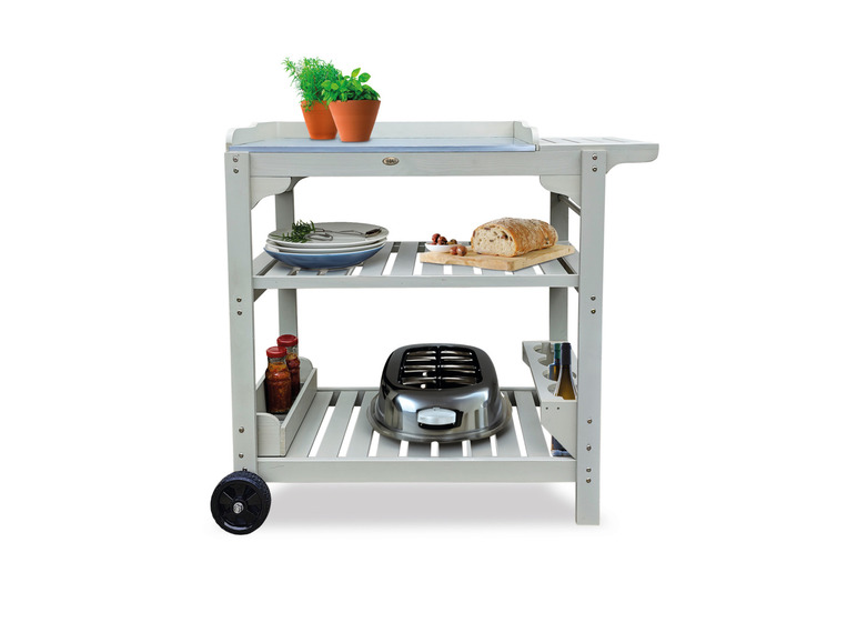 Un chariot de service en bois blanc avec un grille-pain, des assiettes et du pain.