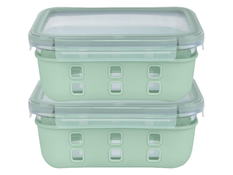 Deux récipients en verre vert avec couvercles.