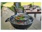 Légumes grillés dans une poêle sur un barbecue au charbon, avec un fond de jardin flou.