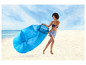 Een vrouw in badkleding draagt een opblaasbare lounger op een strand.