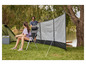 Een windvanger, stoel en een tent op een camping.