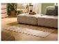 Woonkamer met beige bank, patroonkleed en houten meubels.