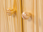 Twee houten knoppen op een houten kastdeur.