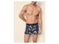Man zonder shirt in blauwe en oranje bloemenprint boxershorts.