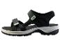 Sandale de sport noire avec des détails verts et une semelle blanche et noire.