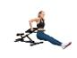 Vrouw doet triceps dips op een zwarte fitnessbank.