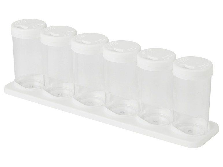 Six pots à épices en plastique blanc avec des trous pour saupoudrer sur un support blanc.