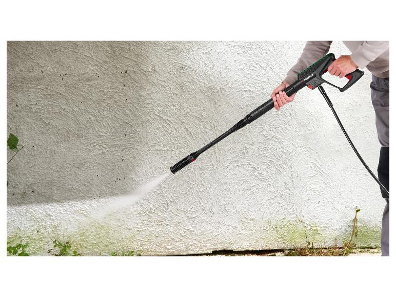 Persoon reinigt een gestructureerde muur met een PARKSIDE hogedrukreiniger.