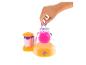 Hand voegt glitter toe aan een Doctor Squish machine met een roze squishy.