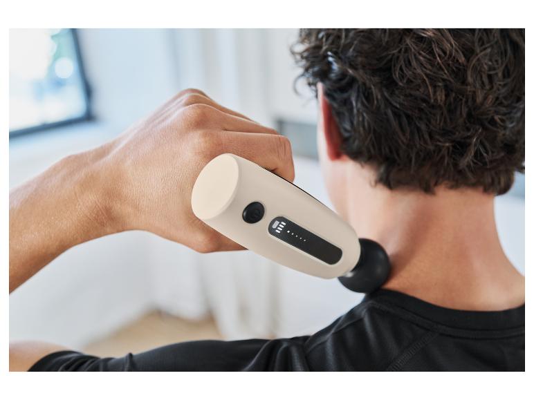 Een man gebruikt een Therabody percussie massage apparaat om zijn nek te ontspannen.