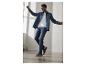 Man in spijkeroverhemd, wit T-shirt, jeans en blauwe sneakers met rubberen zolen.