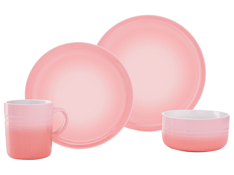 Een roze Le Creuset mok, kom en twee borden.