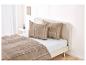 Chambre avec literie à carreaux beige et lit de couleur claire.