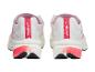 Een paar witte sportschoenen met roze en zwarte details, achteraanzicht.