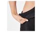 La main d'une personne tirant sur la ceinture d'un legging noir.