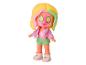 Een pop met roze gezichtmasker en groene komkommer op haar ogen.