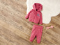 Un sweat à capuche et un pantalon de jogging roses pour bébé avec un hochet rose.