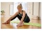 Vrouw in Jette Sport sportkleding doet yoga op een groene mat.
