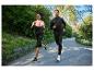 Homme et femme courant en tenue de sport en extérieur.