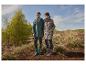 Homme et femme en imperméables et bottes dans la nature, avec des arbres et un ciel bleu en arrière-plan.