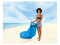 Een vrouw op het strand met een opblaasbare ligstoel.